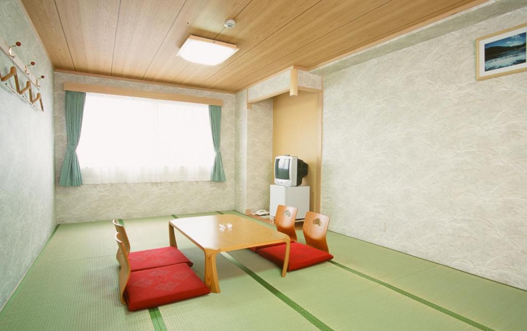 a living room with a table and two chairs at Hotel Station Kyoto West in Kyoto