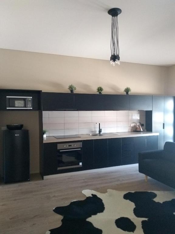 a kitchen with black and white appliances and a couch at Kindred Parkside Apartments in Leeton