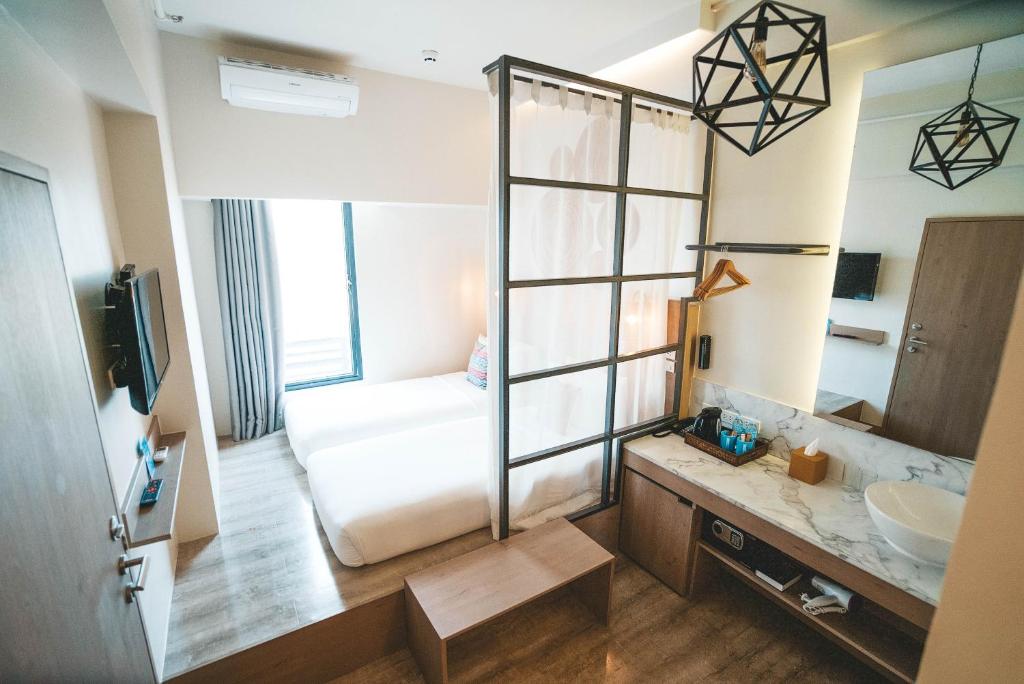 a room with a bed, a desk and a mirror at Lub d Philippines Makati in Manila