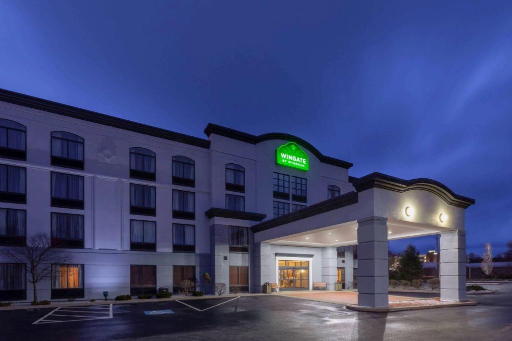 a hotel with a sign on the front of a building at Wingate by Wyndham Erie in Erie