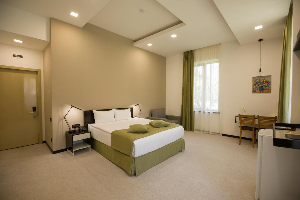 une chambre avec un lit, une table et une fenêtre dans l'établissement AnnaBella Boutique Hotel, à Erevan