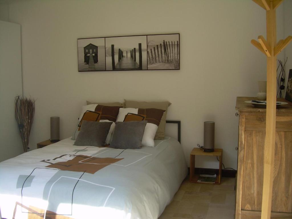 a bedroom with a white bed with two pictures on the wall at L'Annexe in Anzin-Saint-Aubin