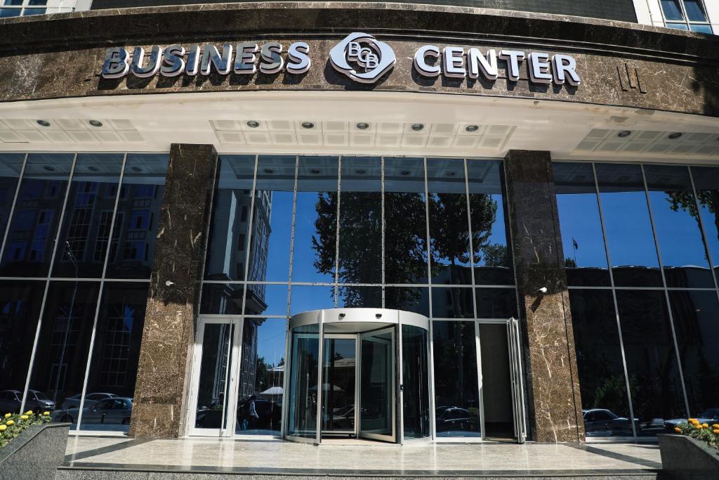a business center with a revolving door in front of it at Bokhtar Apart Hotel in Dushanbe