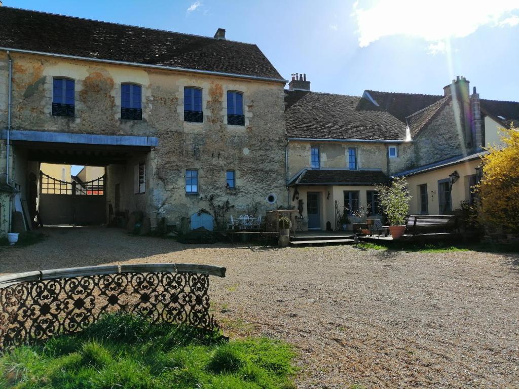 un gran edificio de piedra con ventanas azules y patio en LA GUINGUETTE DE BELLEME, en Bellême