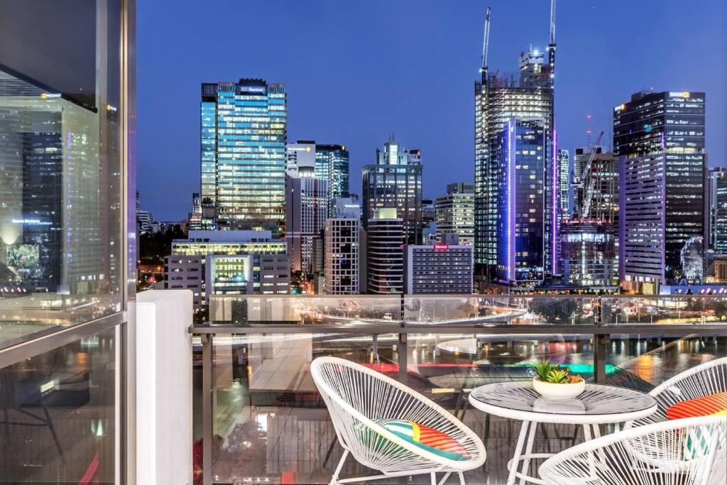einen Balkon mit Tischen und Stühlen und Blick auf die Skyline der Stadt in der Unterkunft South Bank Beautiful river view Tower in Brisbane