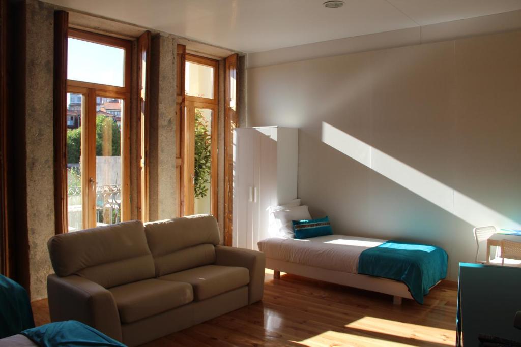 sala de estar con sofá y cama en Loulé Estúdios, en Oporto