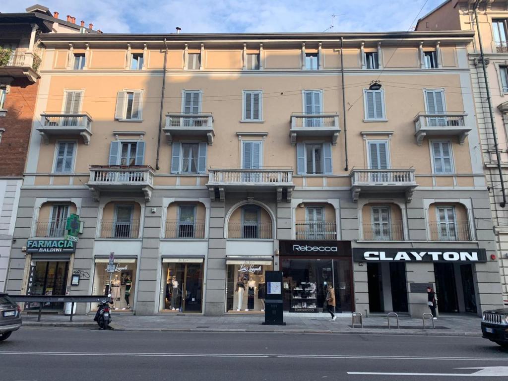 un gran edificio en una calle de la ciudad con una tienda en Lima Apartments en Milán