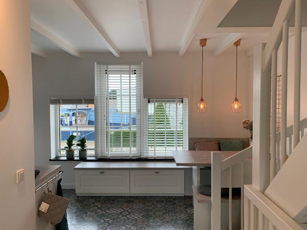 uma cozinha com uma mesa e duas janelas e um balcão em Boothuis Harderwijk em Harderwijk
