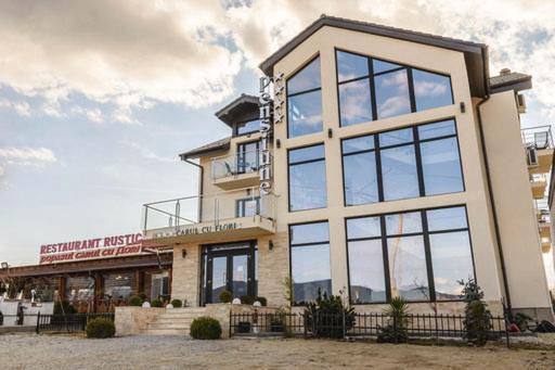 a building with large windows on the side of it at Pensiunea Carul cu flori in Oraviţa