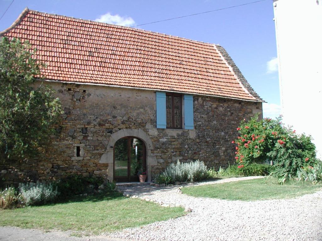 a stone house with a red roof and a doorway at Aveyron West in Saint-Igest