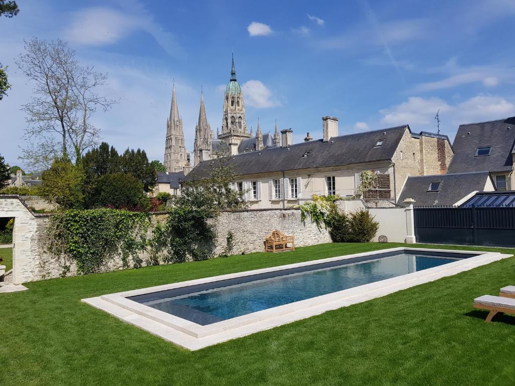 a house with a swimming pool in a yard at Le Tardif, Noble Guesthouse in Bayeux