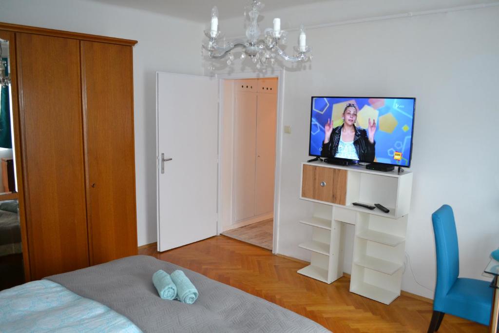 a bedroom with a flat screen tv on a white wall at Serendipity 3 in Pécs