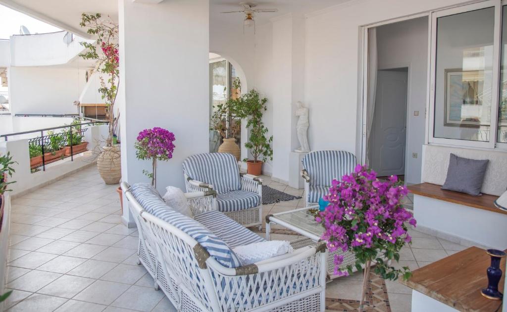 a balcony with chairs and a table and flowers at Casa Bianca - Good Living in Preveza