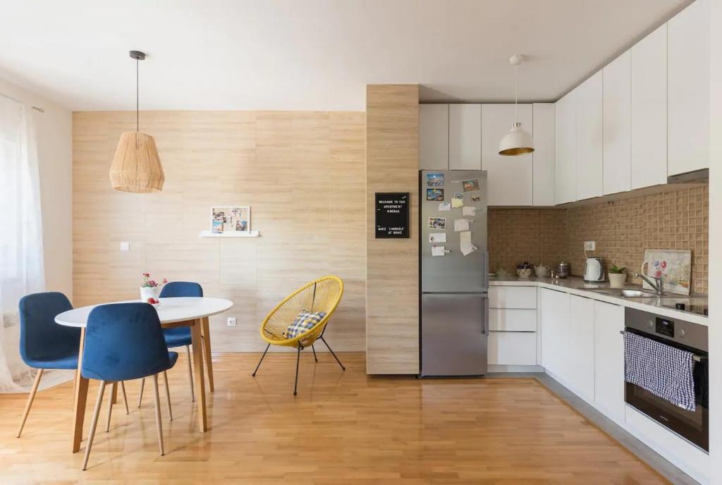 a kitchen with a table and chairs and a refrigerator at Apartment Merak in Mostar