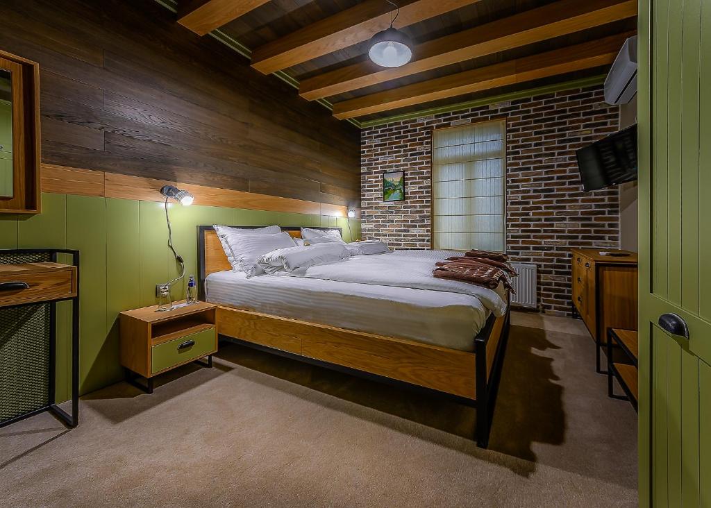 a bedroom with a bed and a brick wall at Vitality Guest House in Veliko Tŭrnovo