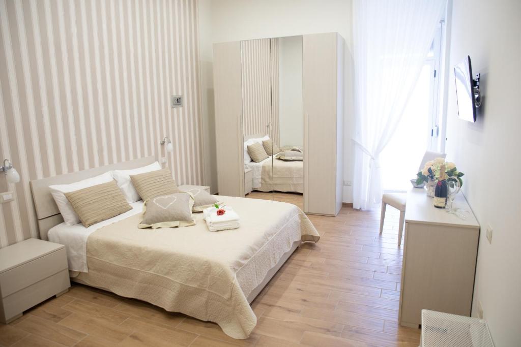 ein weißes Schlafzimmer mit einem Bett und einem Stuhl in der Unterkunft Le Dimore del Corso in Castellammare di Stabia