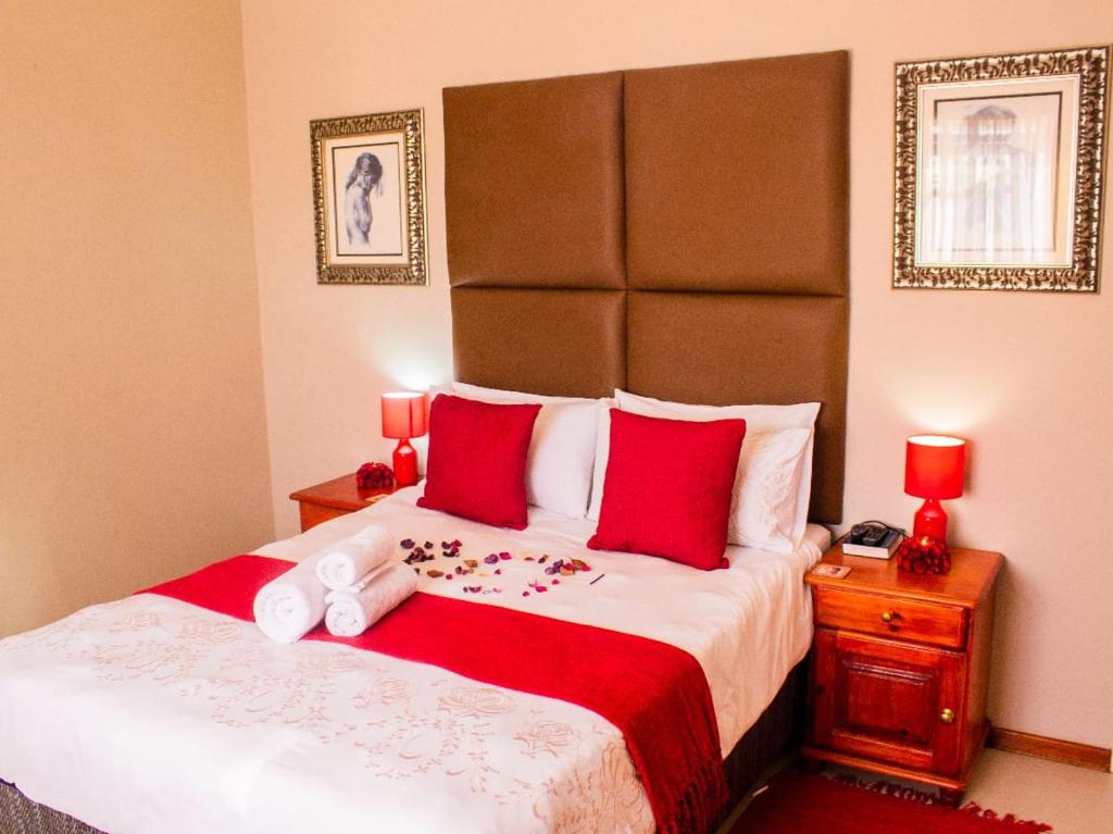 a bedroom with a large bed with red pillows at faces guesthouse in Bethlehem