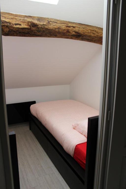 a small bed in a small room with at Gite des Celliers in Alise-Sainte-Reine