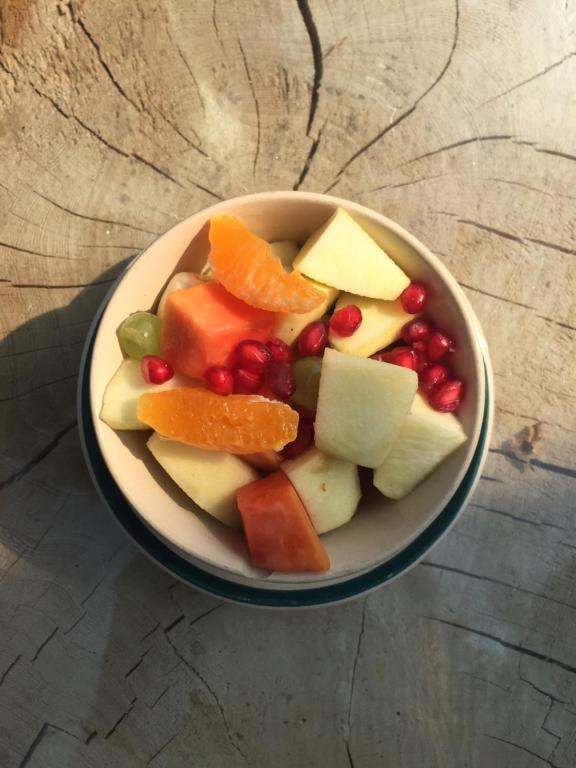a bowl of fruit and vegetables on a table at Hotel At The End Of The Universe in Nagarkot
