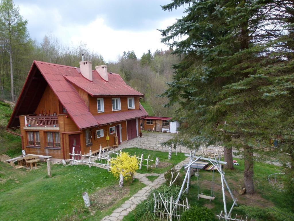 Agroturystyka u Psotki في Kużmina: منزل خشبي كبير بسقف احمر