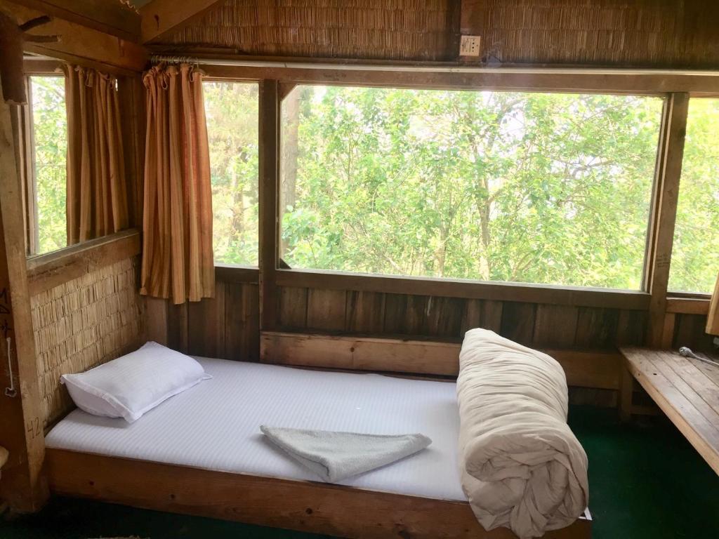 a bed in a room with a window at Hotel At The End Of The Universe in Nagarkot