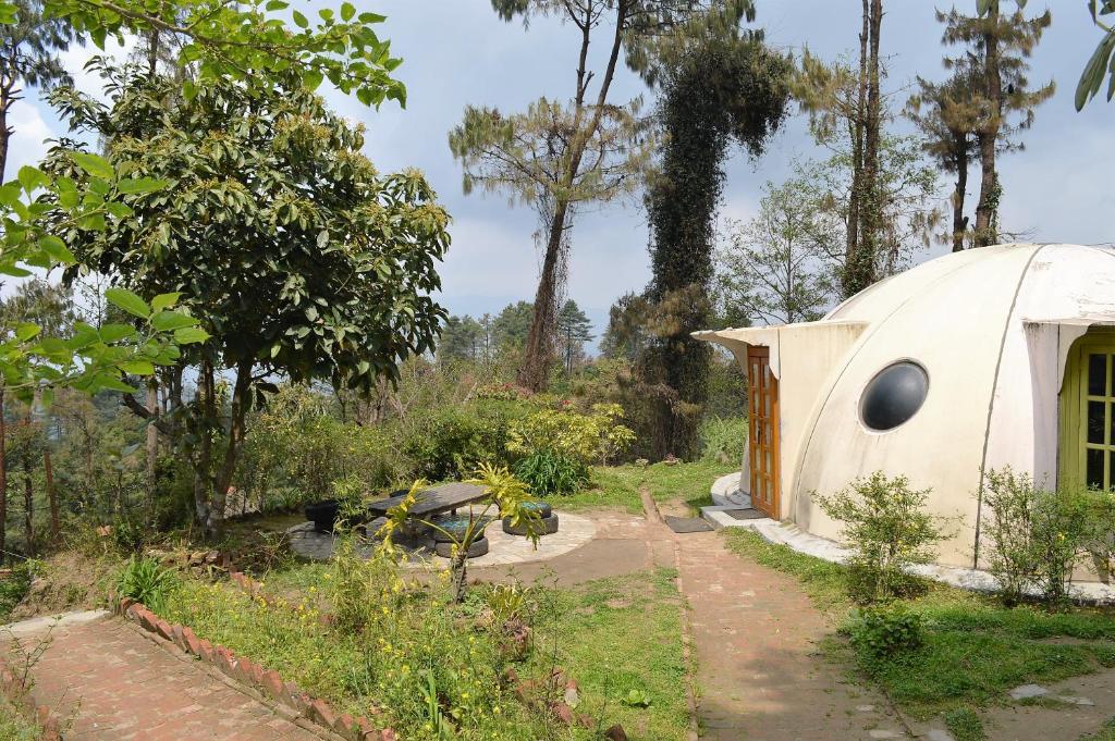 a small white dome house in a garden at Hotel At The End Of The Universe in Nagarkot