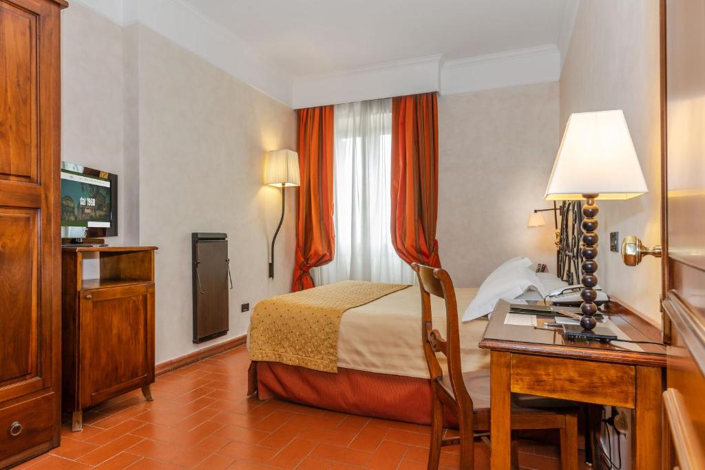 a hotel room with a bed and a desk at Hotel Ristorante La Pergola in Magliano Sabina