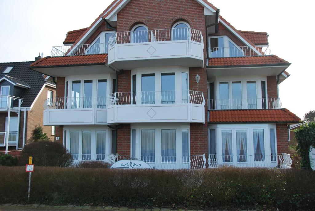ein großes Backsteingebäude mit einem weißen Balkon in der Unterkunft Haus Nordseeperle Whg.5 in Cuxhaven