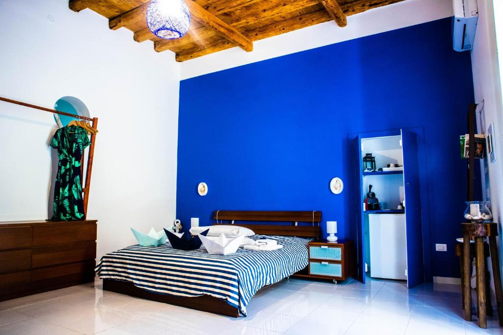 Un dormitorio con una pared azul y una cama en Terra Del Sole, en Trani