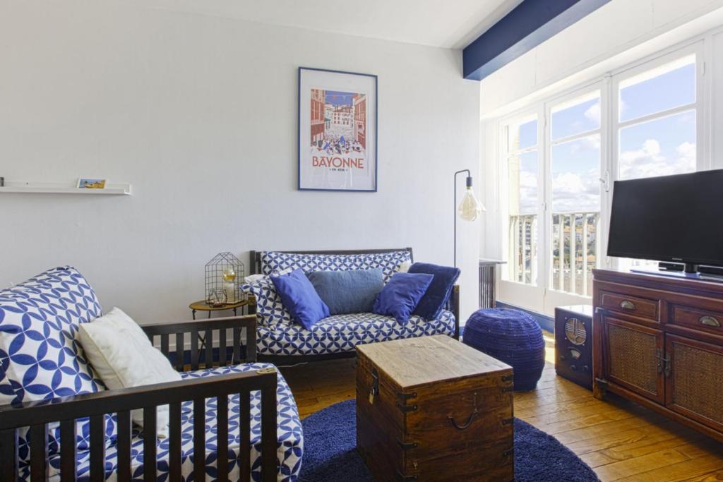 a living room with a couch and a tv at Studio Thalmar - Welkeys in Biarritz