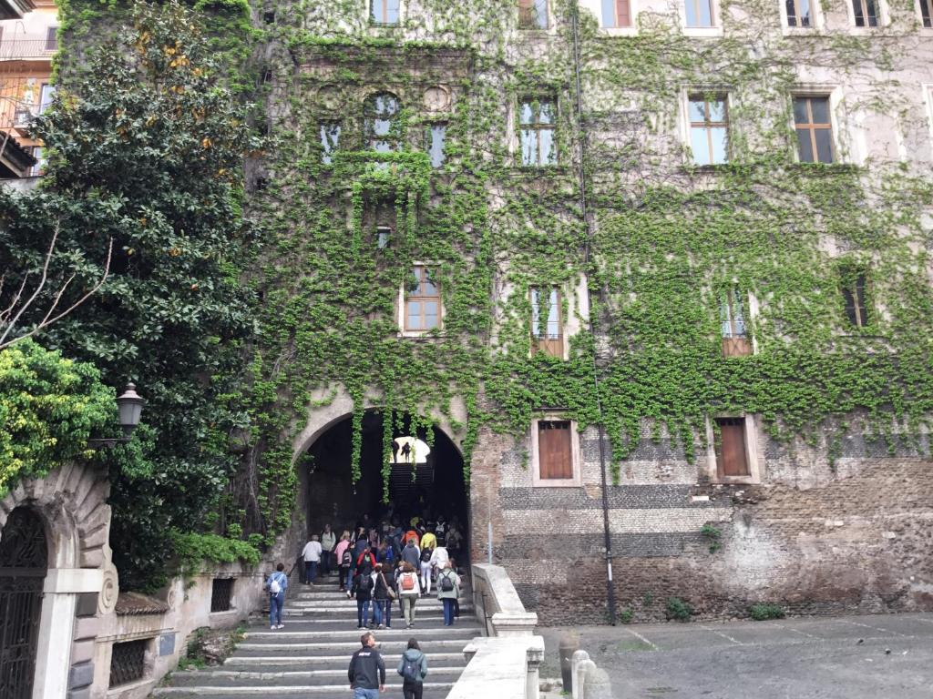 Un groupe de personnes monte les escaliers jusqu'à un bâtiment dans l'établissement Duca di Cavour, à Rome