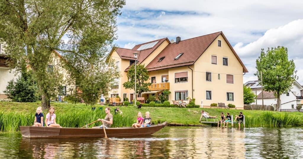 a group of people riding in boats on a river at Bartlhof-Ferienwohnungen-Zimmer in Burglengenfeld