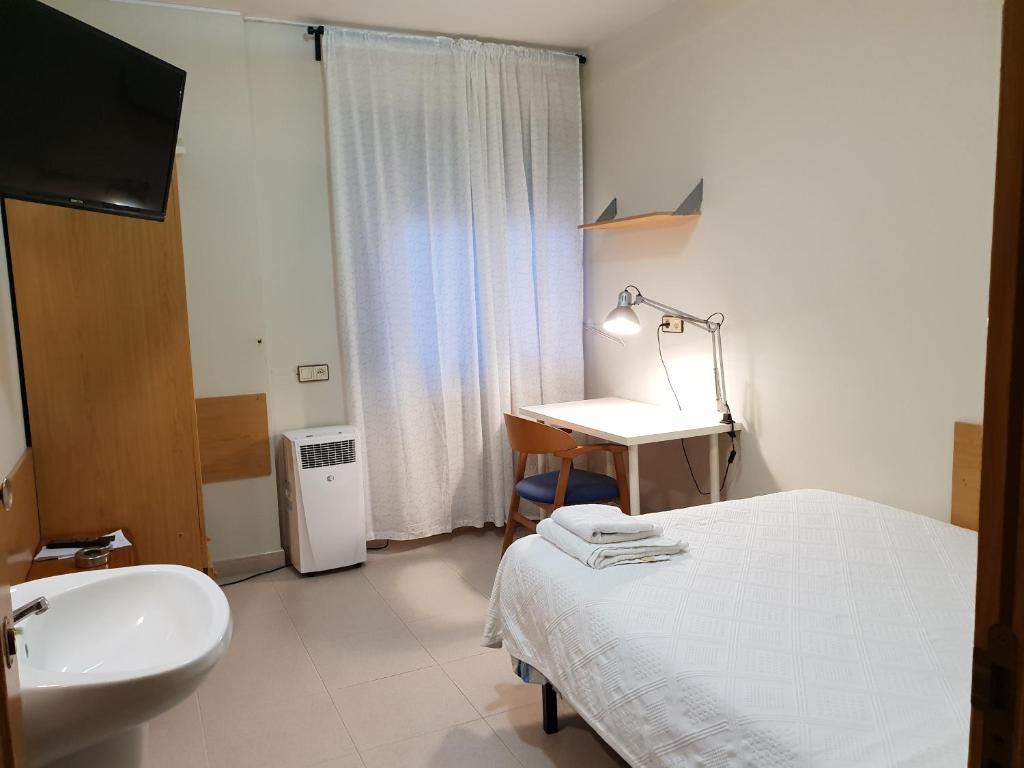 Habitación hospitalaria con cama y lavabo en Residencial Oscense, en Huesca