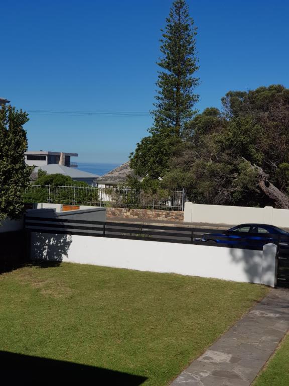 a retaining wall with grass and a car on it at Norfolkden Beachhouse in Hermanus