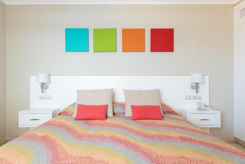a bedroom with a colorful bed with two colorful pillows at Holiday Club Vista Amadores in Amadores