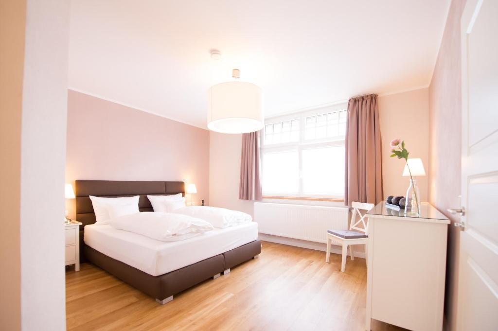 a bedroom with a white bed and a window at Gästehaus C.H.Berres Ürzig-Mosel in Ürzig