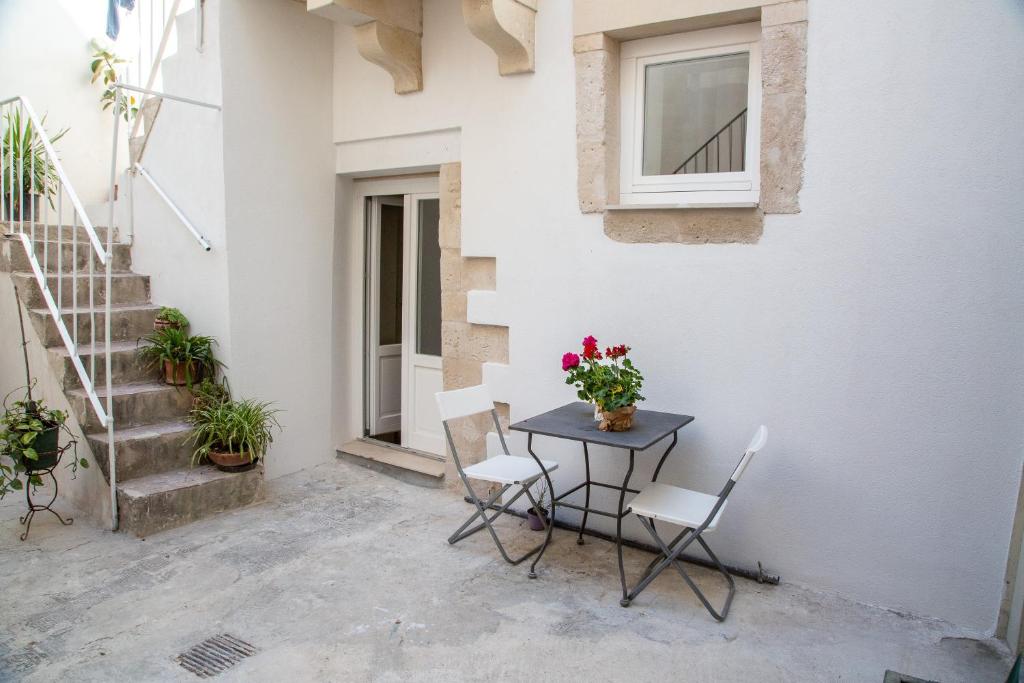 una mesa y sillas en el patio de un edificio en Judaica d'Ortigia, en Siracusa