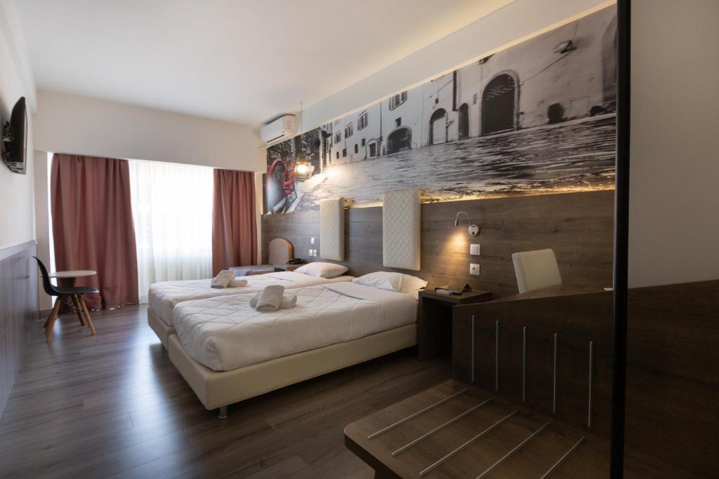 pokój hotelowy z łóżkiem i ścianą z obrazami w obiekcie Metropolitan w Salonikach