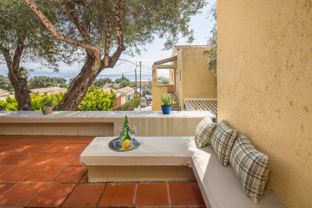 a patio with a bench with a bottle of wine at Pavlina Apartment By Hotelius in Barbati