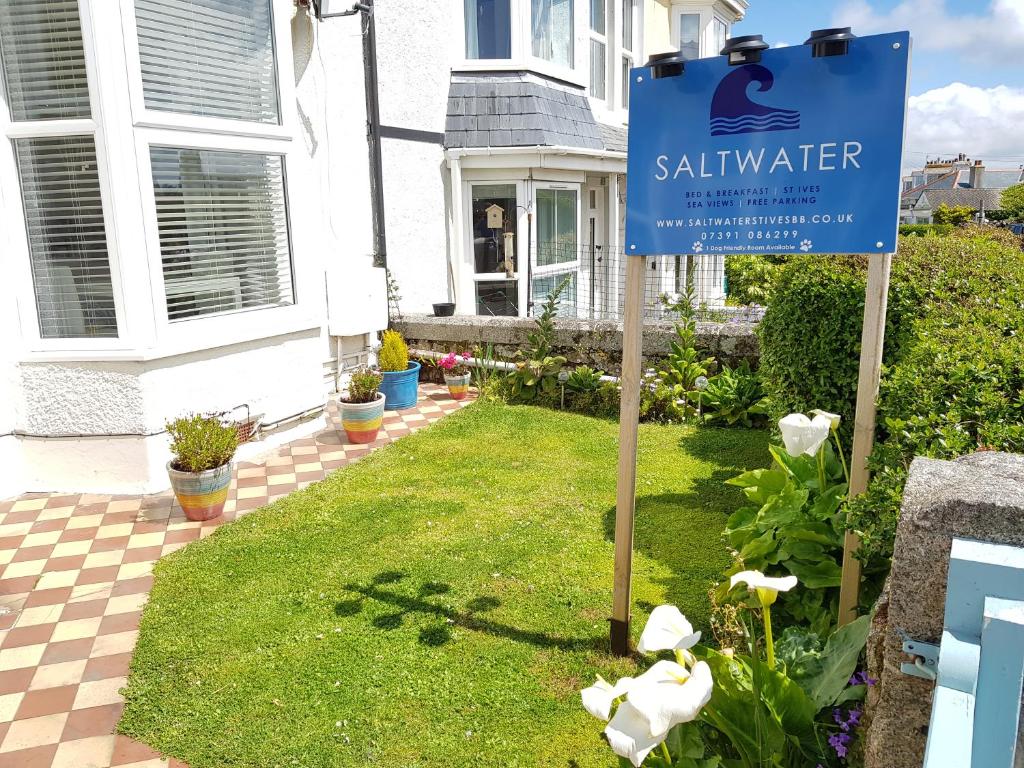un cartel en un patio frente a una casa en Saltwater, en St Ives