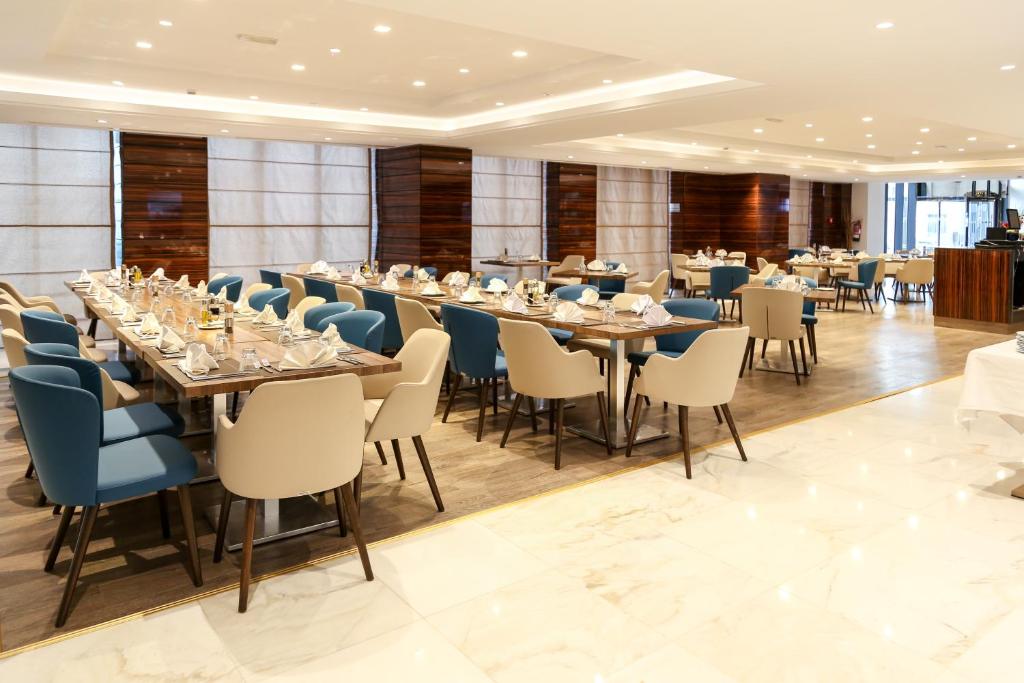 una grande sala da pranzo con tavoli e sedie lunghi di Radisson Hotel Sfax a Sfax