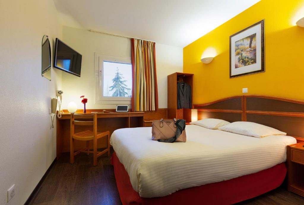 Ein Bett oder Betten in einem Zimmer der Unterkunft Hôtel Roi Soleil Mulhouse-Kingersheim