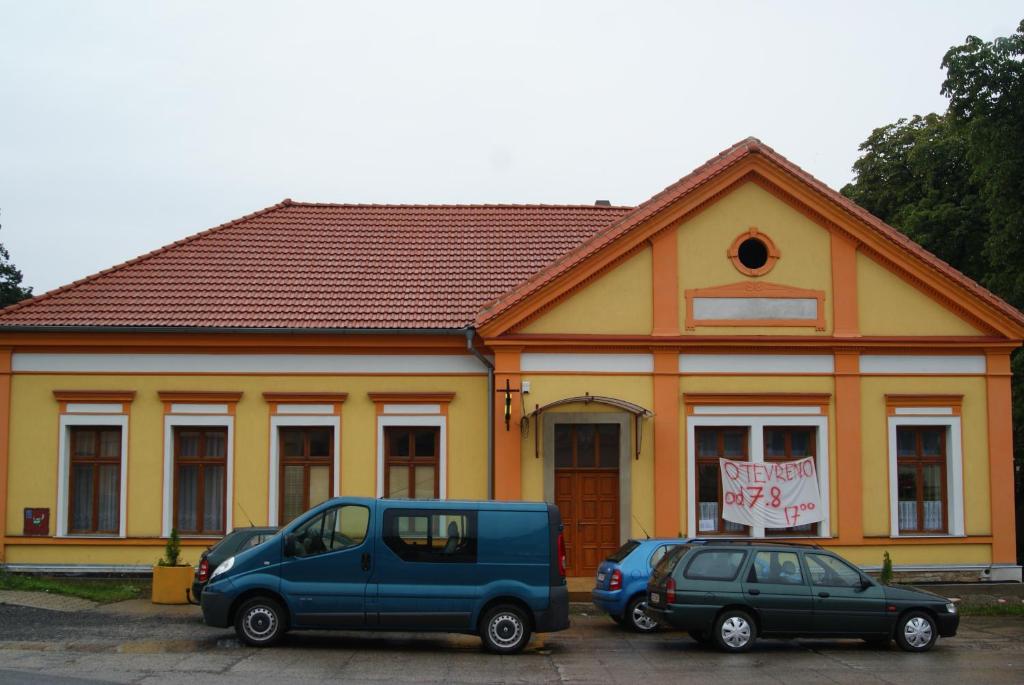 budynek z dwoma samochodami zaparkowanymi przed nim w obiekcie Ubytování U Tajčů w mieście Dolní Beřkovice