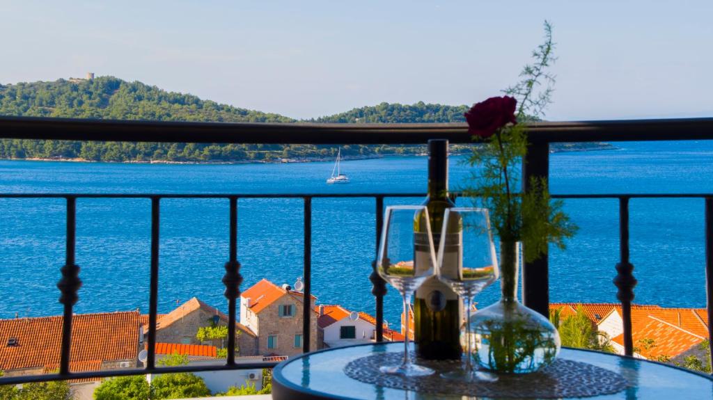 una mesa con una botella de vino y una copa en Apartment Sandra (2+2) with a breathtaking view en Vis