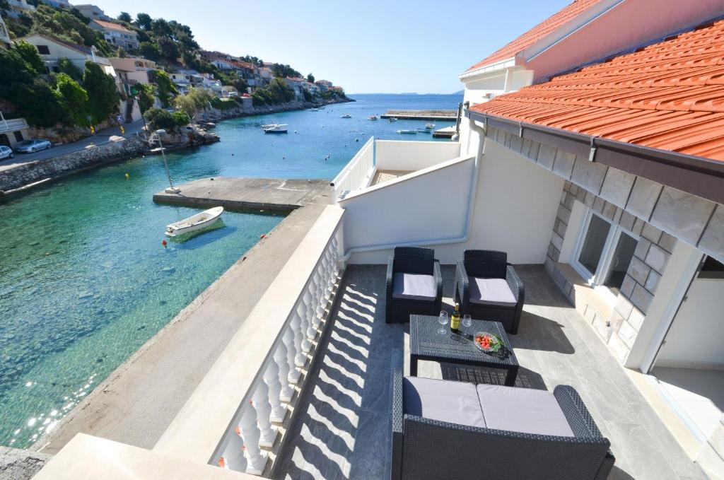 a balcony with chairs and a view of the water at House Riva in Zavalatica