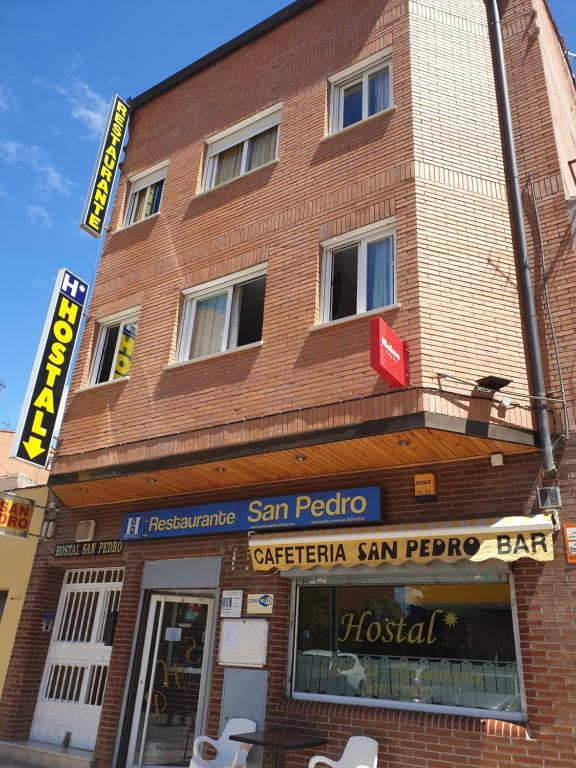 un edificio de ladrillo rojo con un cartel. en Hostal San Pedro, en Coslada