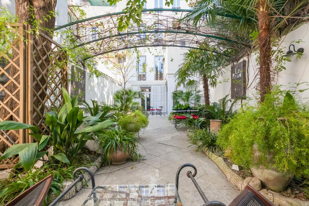 un jardín interior con plantas y bancos en un edificio en Le Ryad Boutique Hôtel, en Marsella