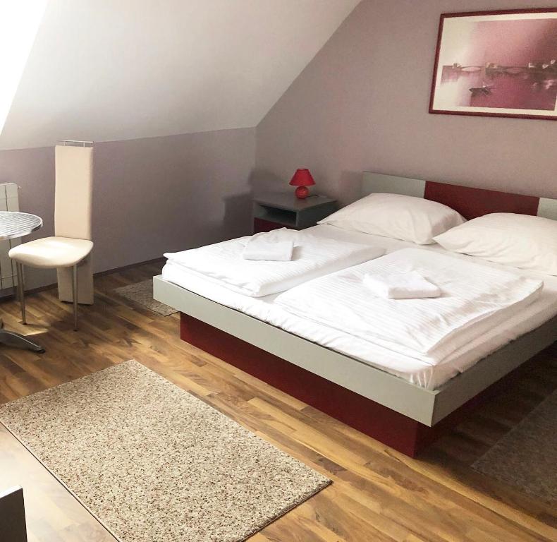 1 dormitorio con cama blanca y mesa en Guest House Aleksandra en Bajina Bašta