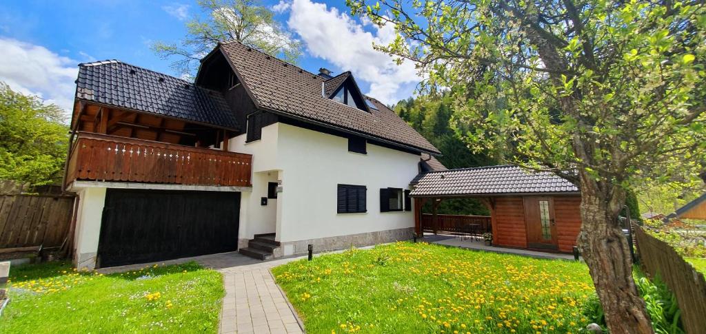 a white house with a garage and a fence at Apartment Alpska Astra in Kranjska Gora