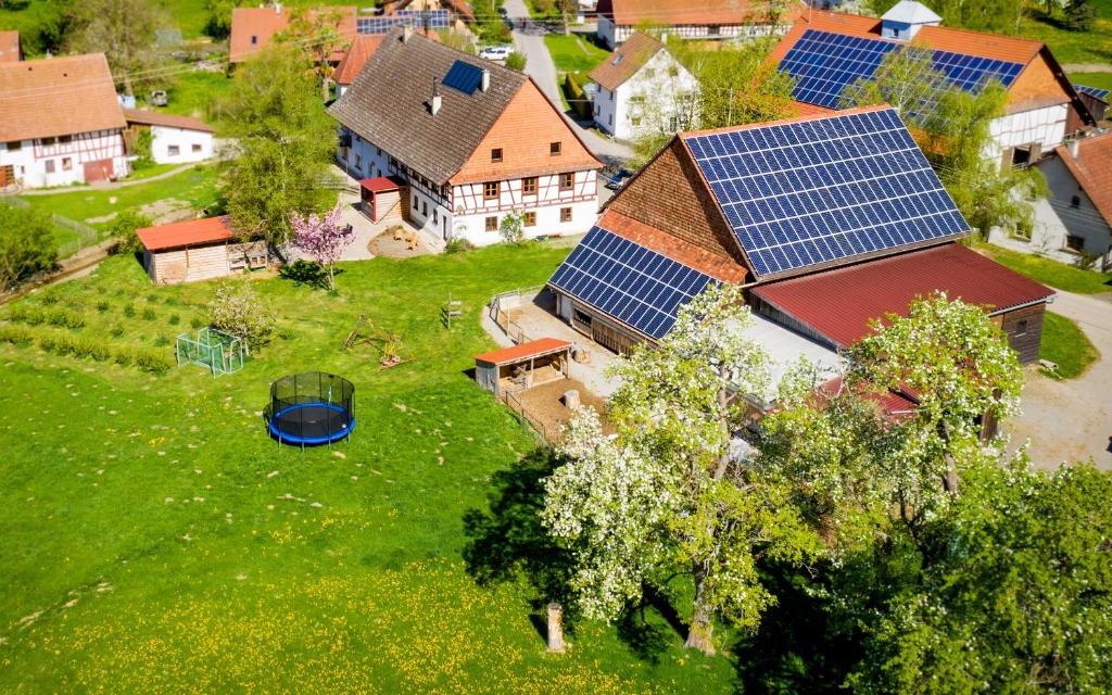 an aerial view of a house with solar panels on its roof at Ferienwohnung Kapellenhof in Herdwangen-Schönach